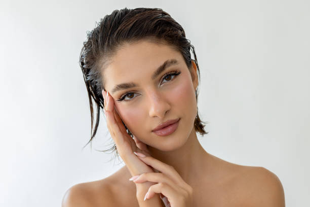 Young and beautiful woman with wet hair against white background