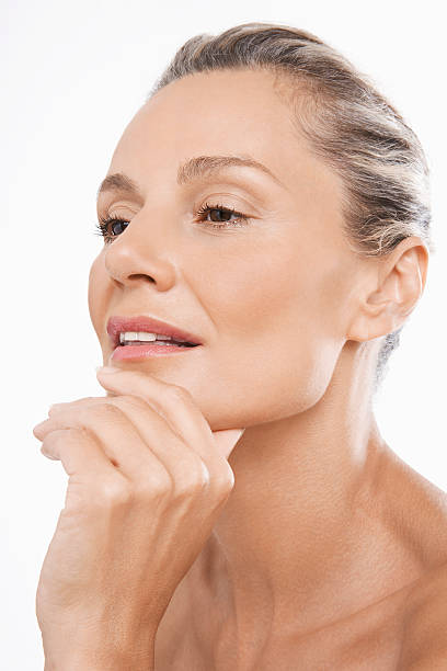 Closeup of thoughtful middle aged woman with hand on chin over white background