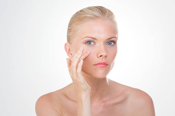 blond woman touching her cheek with her hand