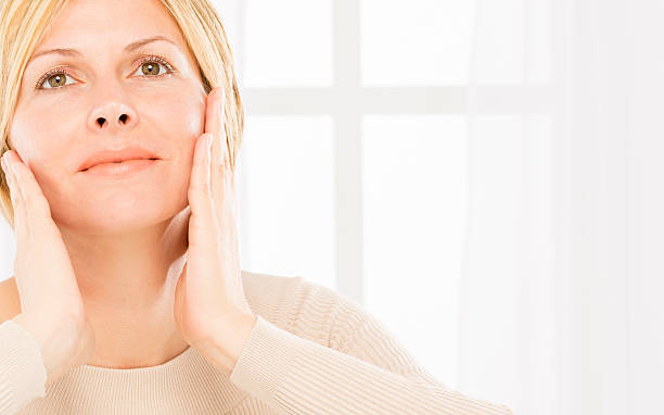 Satisfied middle aged woman with tenderness and care skin.