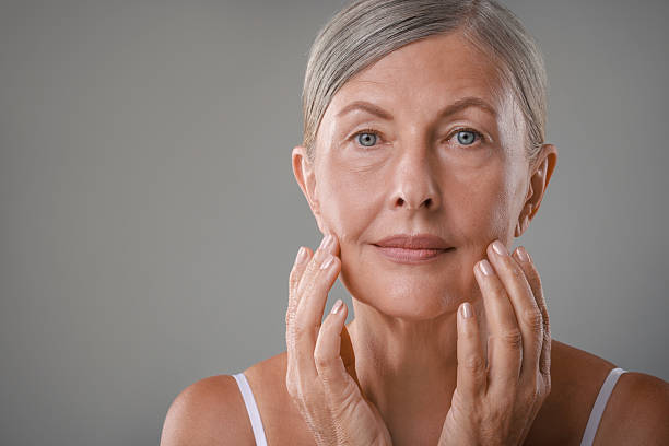 Face massage. Beautiful woman with healthy skin on grey background