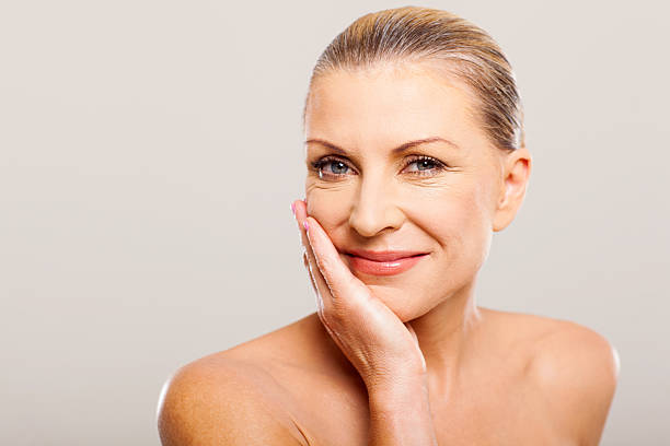 modern senior woman with hand on her face over white backround
