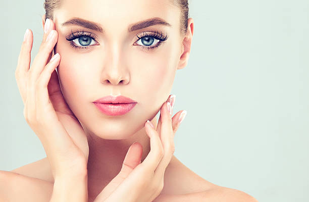 Close-up portrait of young woman with clean fresh skin. Make-up and manicure.