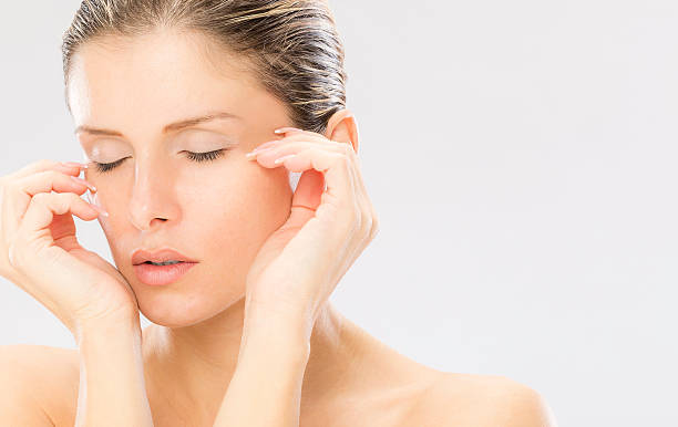 Picture of woman with closed eyes and tenderness skin at gray background.