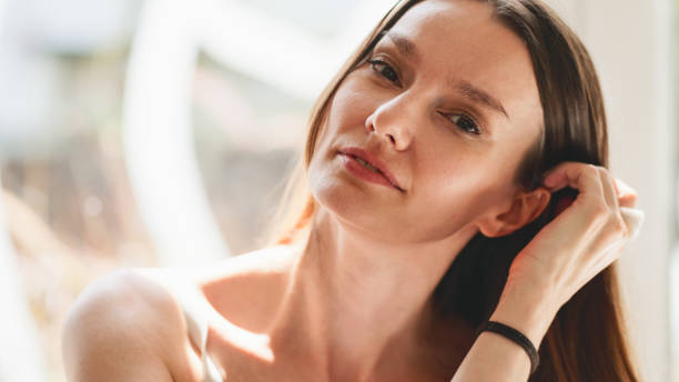 Close-up portrait of beautiful young adult woman in the sunlight at sunset.